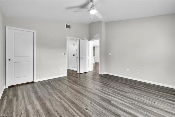 Unfurnished bedroom with vaulted ceiling, wood finished floors, and a ceiling fan