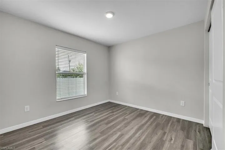 Unfurnished bedroom with wood finished floors and a closet