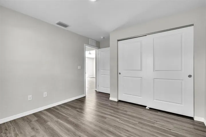 Unfurnished bedroom with light wood-style floors and a closet