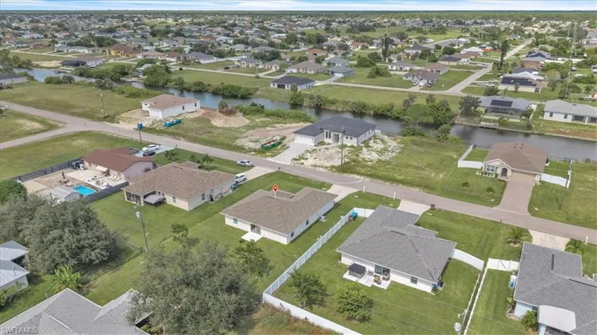 Aerial view of property and surrounding area with nearby suburban area and a nearby body of water