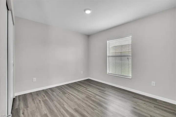 Spare room featuring light wood-style flooring and baseboards