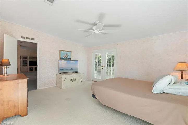 Bedroom featuring wallpapered walls, visible vents, access to exterior, and french doors