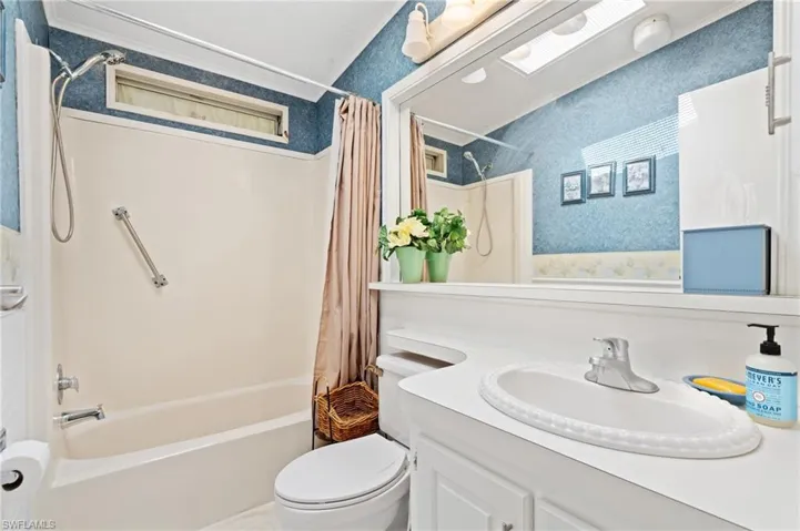 Full bathroom featuring vanity, shower / tub combo, and toilet