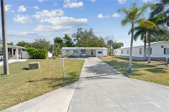 Manufactured / mobile home with a front yard and driveway