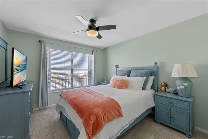 Bedroom with ceiling fan and light carpet