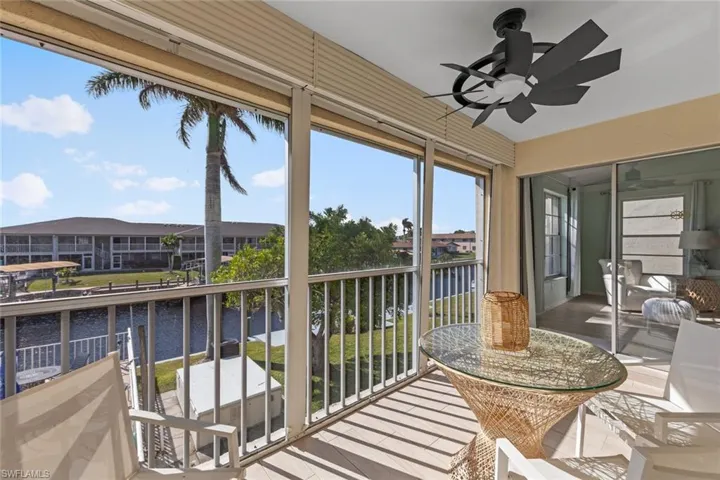 Sunroom with ceiling fan and a water view