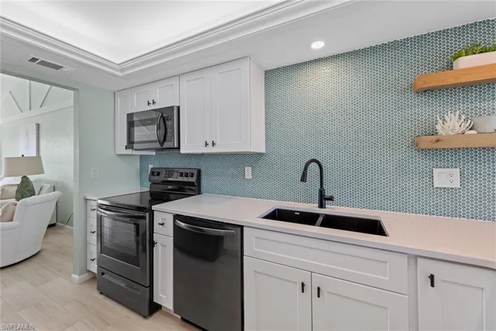 Kitchen featuring white cabinets, appliances with stainless steel finishes, and sink