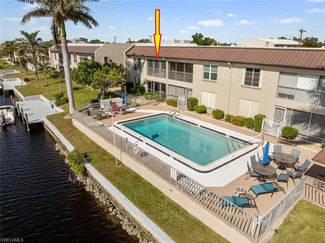 View of swimming pool featuring a boat dock, a patio area, and a water view