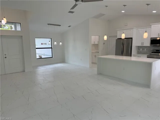Kitchen featuring stainless steel appliances, a healthy amount of sunlight, and light tile patterned floors