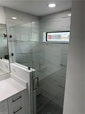 Bathroom featuring vanity, washer / clothes dryer, and walk in shower