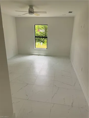 Spare room featuring light tile patterned flooring and ceiling fan