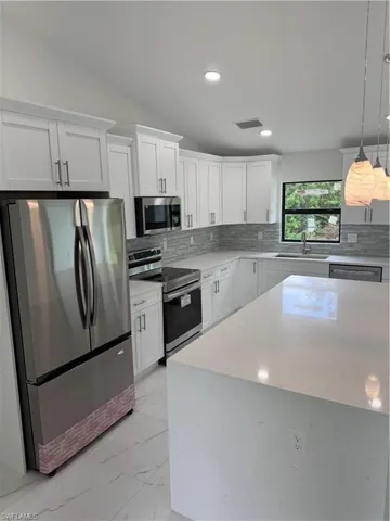 Kitchen with backsplash, range, light tile patterned floors, and refrigerator