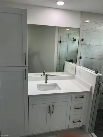 Bathroom with walk in shower, tile patterned flooring, and vanity