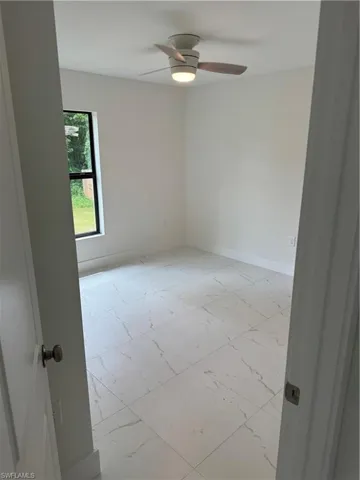Unfurnished room featuring light tile patterned floors and ceiling fan