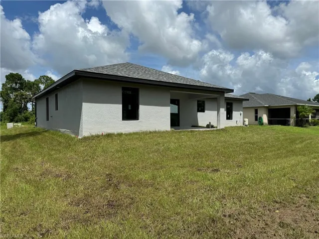 Rear view of house featuring a lawn