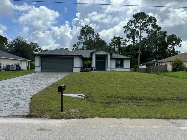 Single story home with cooling unit, a garage, and a front yard