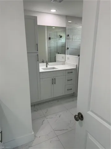 Bathroom featuring vanity, tile patterned flooring, and tiled shower
