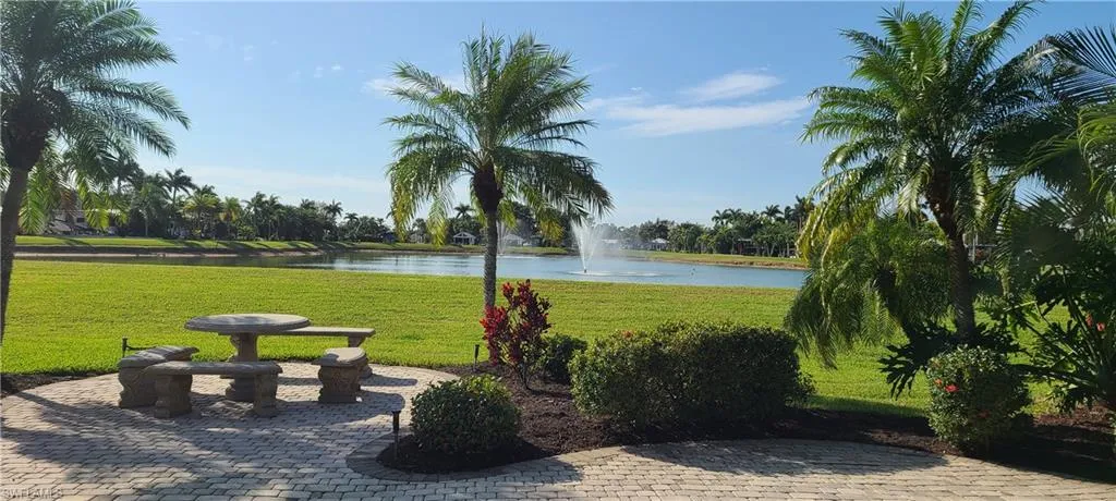 Surrounding community with a water view and a lawn