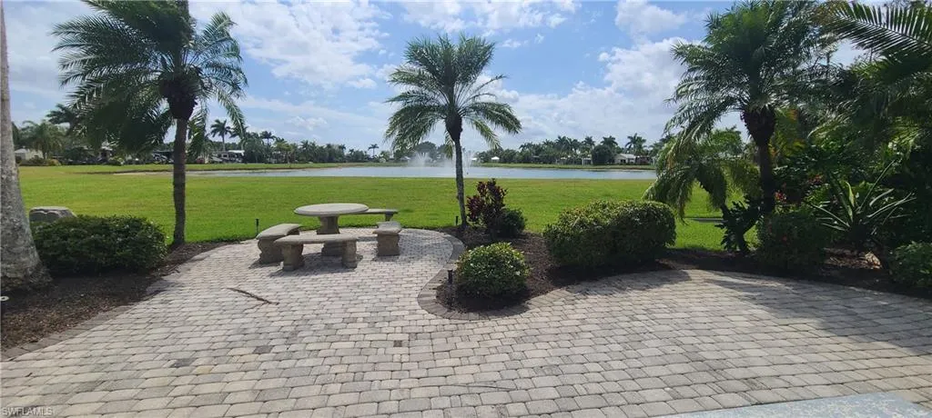 View of property's community with a water view, a patio, and a yard