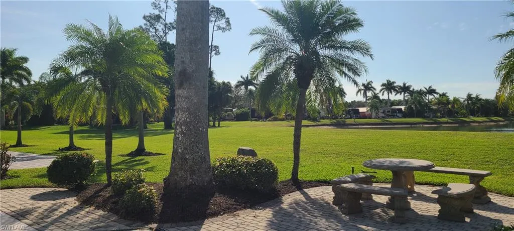 View of home's community with a water view and a lawn