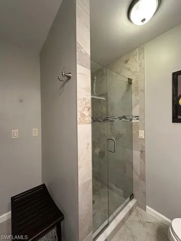 Full bathroom featuring baseboards and a stall shower