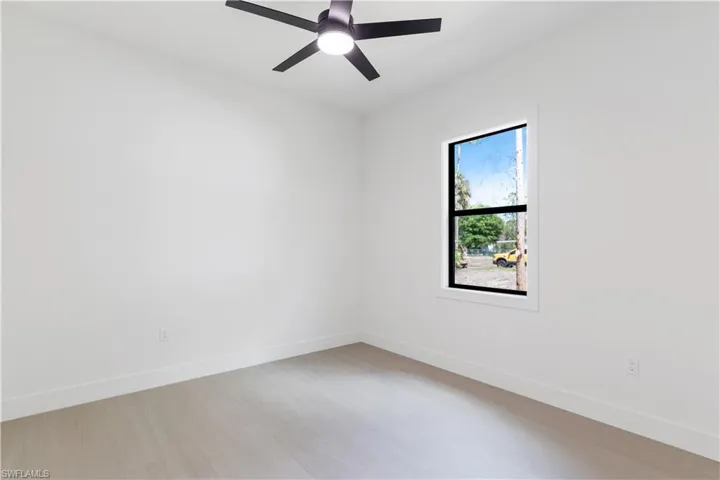 Bedroom with light floor and a ceiling fan
