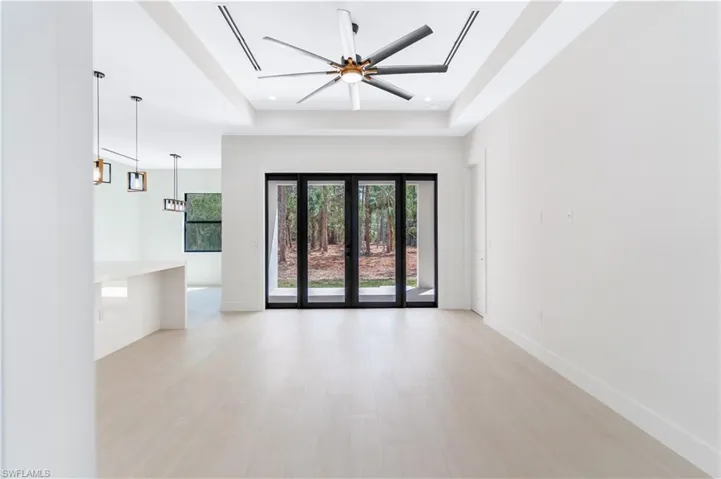 Living room featuring a tray ceiling, wood look tile, french doors, a ceiling fan, and recessed lighting
