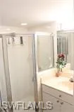 Full bath featuring vanity and a shower stall