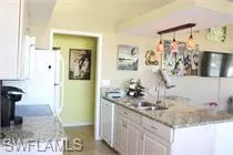 Kitchen with freestanding refrigerator and white cabinetry
