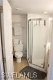 Bathroom with a shower stall and toilet