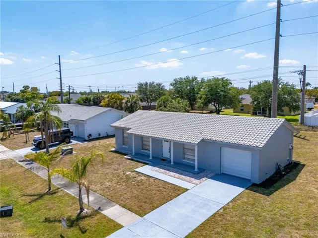 Ranch-style home with a front lawn, stucco siding, driveway, a porch, and a garage