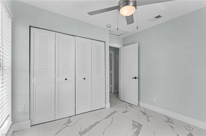 Unfurnished bedroom featuring visible vents, baseboards, marble finish floor, and a closet