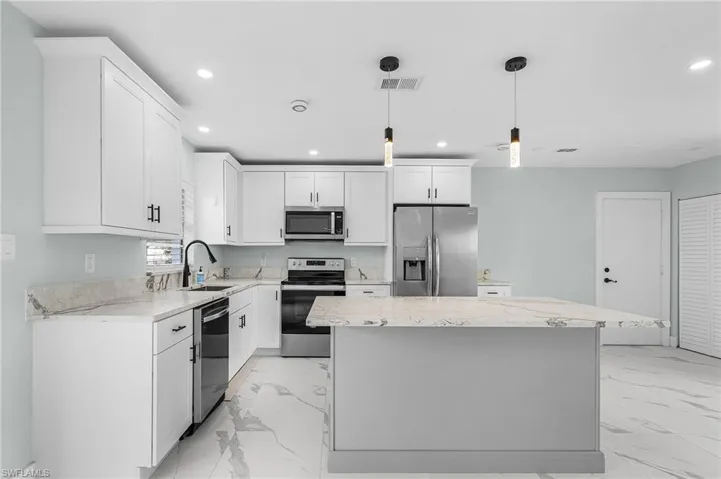 Kitchen with recessed lighting, marble finish floor, stainless steel appliances, and a sink