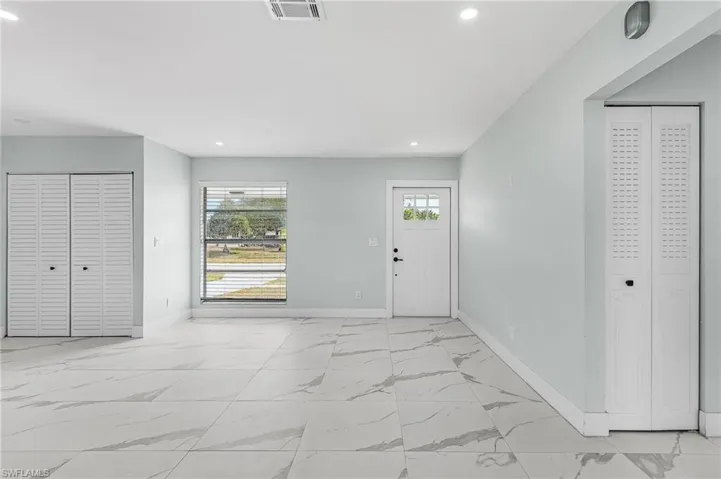 Foyer featuring marble finish floor, baseboards, visible vents, and recessed lighting