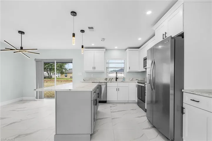 Kitchen with visible vents, plenty of natural light, marble finish floor, and appliances with stainless steel finishes