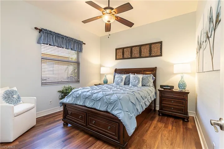 Bedroom featuring a ceiling fan, dark wood-style flooring, and baseboards
