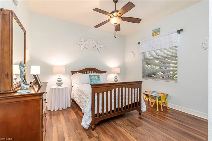Bedroom featuring a ceiling fan, dark wood finished floors, and baseboards