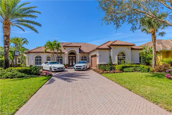 Mediterranean / spanish home with a garage, a tiled roof, decorative driveway, and stucco siding