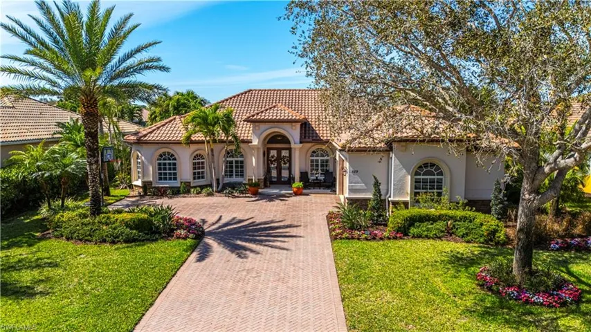 Mediterranean / spanish home featuring french doors, a front lawn, decorative driveway, and stucco siding