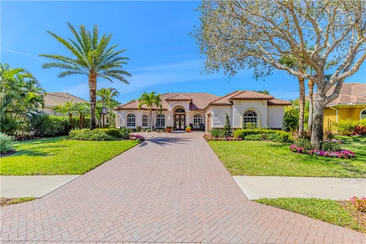 Mediterranean / spanish-style house with stucco siding, a tile roof, decorative driveway, and a front yard