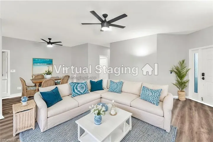 Virtually staged Living room and Dining room area. Sectional couch faces large wall space for TV & furniture