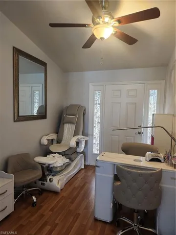 Office area with dark hardwood / wood-style floors and ceiling fan