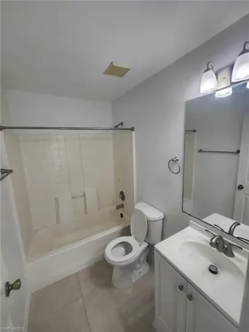 Full bathroom with tile patterned flooring, toilet, shower / bathtub combination, and vanity
