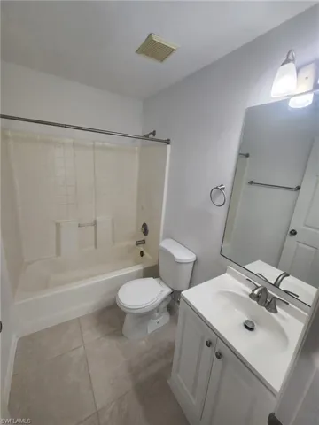 Full bathroom with vanity, tile patterned flooring,  shower combination, and toilet