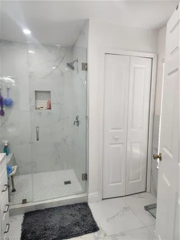 Bathroom featuring tile flooring, an enclosed shower, and vanity