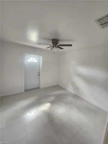 Spare room featuring ceiling fan and light tile patterned floors