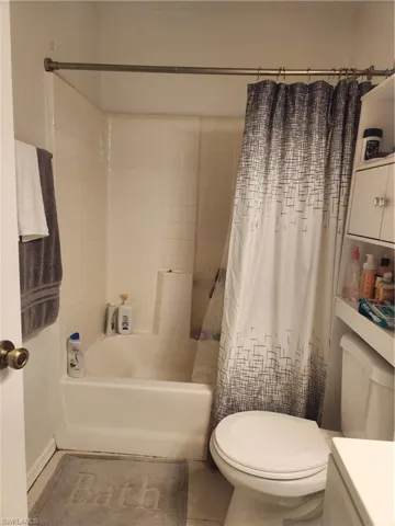 Bathroom with tile flooring, toilet, and shower / bath combo