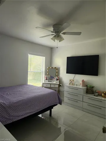 Tiled bedroom featuring ceiling fan