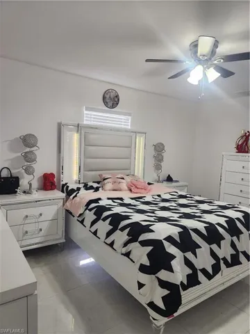 Tiled bedroom featuring ceiling fan