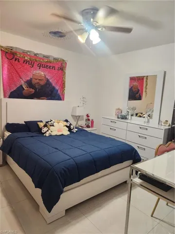 Bedroom with ceiling fan and light tile flooring